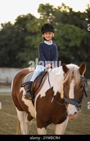 la fille monte le cheval à l'entraînement Banque D'Images