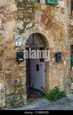 Porte en bois d'une résidence dans la ville médiévale fortifiée de Monteriggioni, Sienne, Toscane, Italie. Banque D'Images