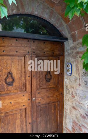 Porte en bois d'une résidence dans la ville médiévale fortifiée de Monteriggioni, Sienne, Toscane, Italie. Banque D'Images