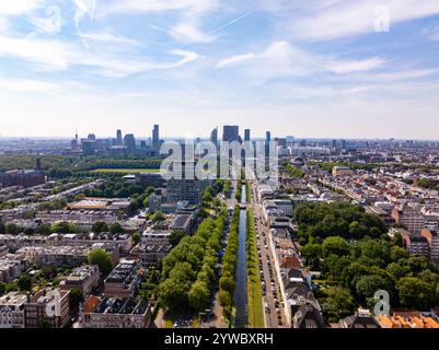 Vue panoramique sur la ville de la Haye avec des bâtiments modernes, des espaces verts, un canal et des voitures garées lors d'une journée d'été ensoleillée en Hollande Banque D'Images