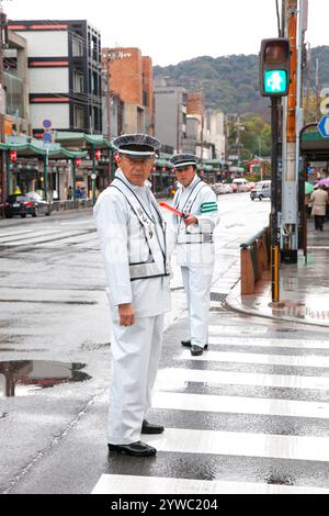 Police de la circulation à Shijo Street dans le centre-ville de Gion, Kyoto, Japon pendant la pluie. Banque D'Images