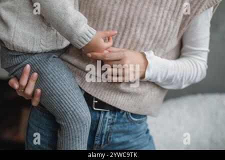 Gros plan au milieu de la section d'une femme portant sa fille et tenant sa main Banque D'Images