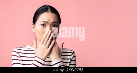 Oh non. Portrait d'une femme asiatique choquée couvrant la bouche avec les mains Banque D'Images