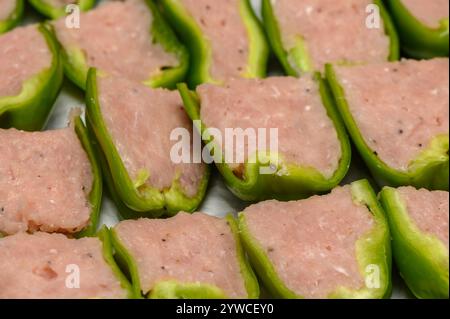 Poivrons farcis colorés remplis de viande salée prêts pour un délicieux repas dans une ambiance de cuisine chaleureuse. Banque D'Images