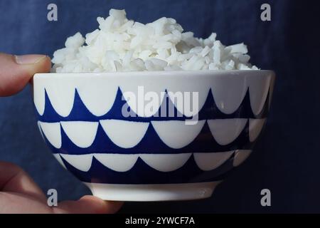 Tenant un bol de riz blanc Banque D'Images