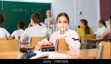 La fille se retourna et regarda la caméra pendant la leçon en classe Banque D'Images