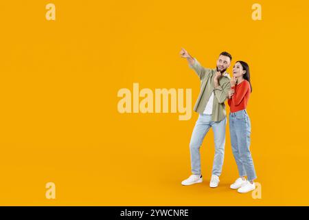 Jeune couple partage un moment joyeux en pointant et en riant ensemble Banque D'Images