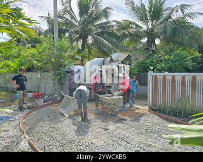 Pattaya, Thaïlande 29 novembre 2024, une équipe travaille avec diligence pour couler et tamponner du béton dans un quartier résidentiel de Pattaya. L’agitation et la coordination de ces travailleurs soulignent leur savoir-faire. Banque D'Images
