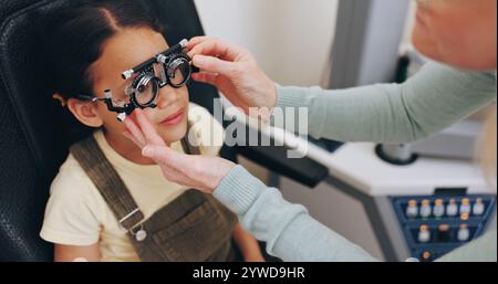 Monture d'essai, mains ou fille dans le test oculaire à la clinique d'optométrie pour les lunettes, la santé de la rétine ou le bien-être de la vue. Examen de la vision, médecin ou enfant de sexe féminin dans Banque D'Images