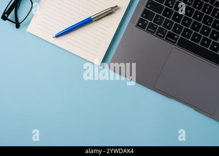 Vue de dessus du bureau bleu avec ordinateur portable et fournitures. Concept commercial Flat lay Banque D'Images