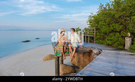 Un couple profite d'un moment paisible sur la plage de Koh Munnork Island Thaïlande, entouré d'eaux tranquilles et d'une végétation luxuriante. Le soleil chaud ajoute à t Banque D'Images