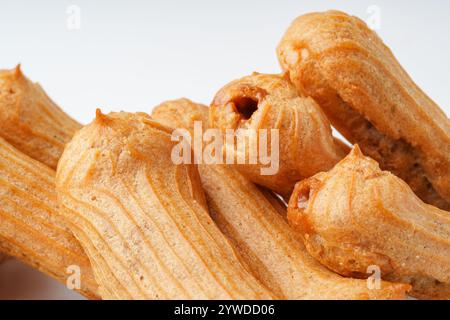 Churros croustillants empilés haut sur un fond blanc invitant à la douceur douce à tout moment de la journée Banque D'Images