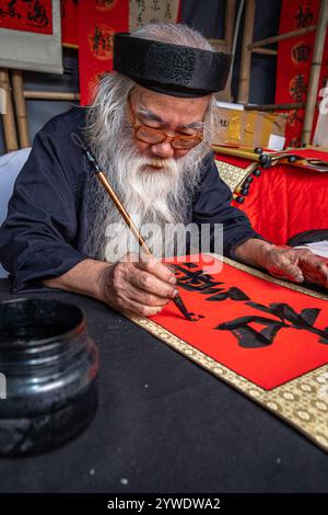 Vietnam, Hanoi, 2024-02-14, festival Têt, nouvel an chinois, vieil homme à longue barbe blanche, calligraphie, calligraphe, photographie de Jean-Yves Bardin Banque D'Images