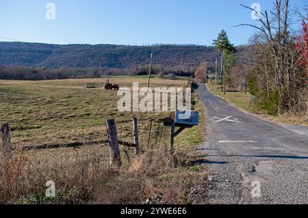 Route rurale dans le pays avec boîte aux lettres et lignes de passage de chemin de fer sur la route bien usée Banque D'Images