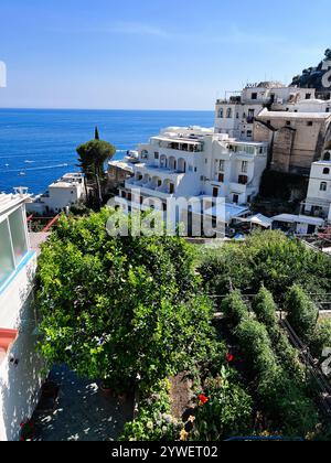 Charmant village méditerranéen surplombant la mer bleue avec des jardins luxuriants, des bâtiments blancs et un paysage naturel animé, offrant un cadre paisible et pic Banque D'Images