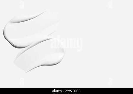 Frottis de crème cosmétique blanche sur un fond clair Banque D'Images