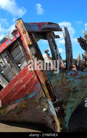 Vieux bateau de pêche coloré en décomposition sur une plage Banque D'Images