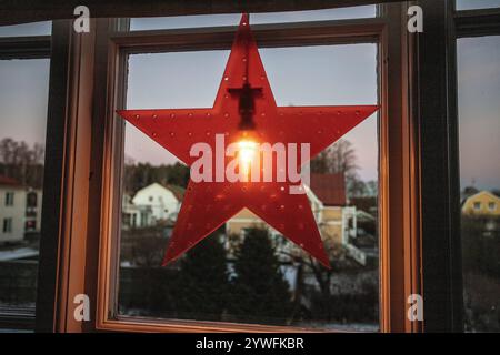 Décorations de noël étoile de l'Avent électrique dans la fenêtre avec de la neige à l'extérieur dans l'après-midi en suède Banque D'Images
