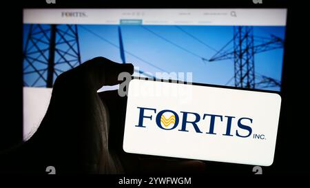 Allemagne. 23 juillet 2024. Dans cette illustration photo, une personne tient un téléphone portable avec le logo de la compagnie canadienne de services publics d'électricité Fortis Inc devant la page Web de l'entreprise. (Photo timon Schneider/SOPA images/SIPA USA) *** strictement à des fins éditoriales *** crédit : SIPA USA/Alamy Live News Banque D'Images