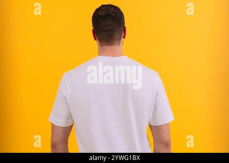 Vue arrière Portrait homme en t-shirt blanc sur fond jaune. Banque D'Images