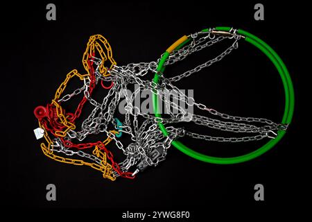 Chaînes à neige neuves avec éléments en plastique rouge, jaune et vert sur fond noir. Banque D'Images