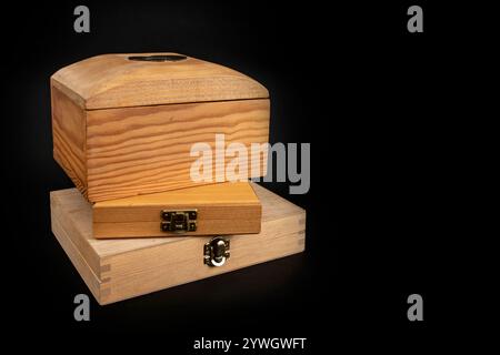 Boîtes en bois avec couvercle fermé empilées et isolées sur fond noir, Banque D'Images