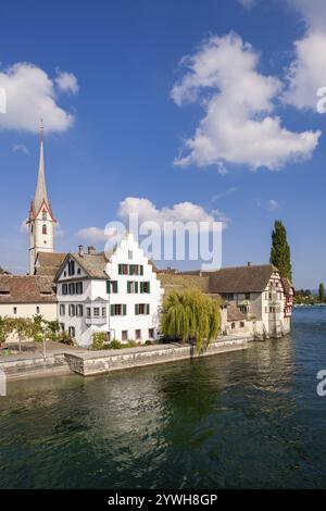 Maison à colombages et tour d'église sur une rivière claire sous un ciel bleu, vue sur la vieille ville de Stein am Rhein avec monastère de George, Stein am R. Banque D'Images