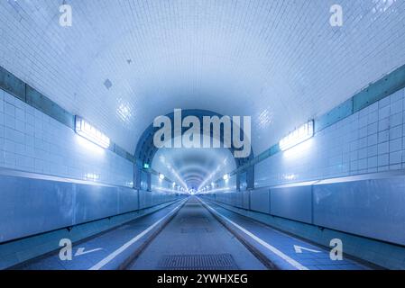 Le tunnel bleu clair s'étend devant vous avec des lumières brillantes éclairant le chemin Banque D'Images