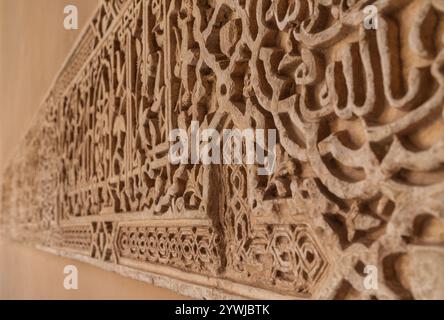 Détails de la décoration en stuc avec des écrits arabes peints en bleu sur les murs des palais dans le complexe de l'Alhambra, Grenade, Andalousie, Espagne. Banque D'Images