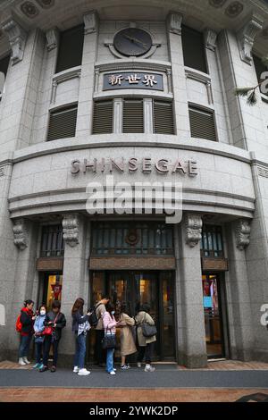 SÉOUL, CORÉE DU SUD - 6 AVRIL 2023 : les gens attendent l'ouverture du grand magasin Shinsegae dans le quartier commerçant de Myeongdong à Séoul la nuit. Banque D'Images