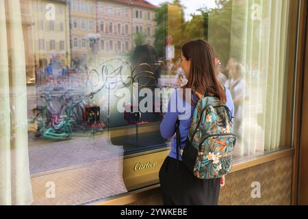 PRAGUE, RÉPUBLIQUE TCHÈQUE - 2 MAI 2024 : Shopper regarde la vitrine du magasin de bijoux de luxe Cartier dans la rue Parizska connue pour la mode haut de gamme s. Banque D'Images