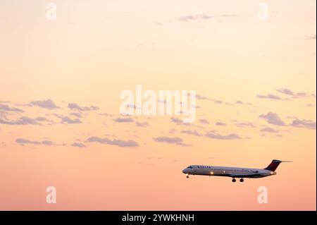Delta Air Lines jet (McDonnell Douglas MD-88) atterrissant à l'aéroport international Hartsfield-Jackson Atlanta au coucher du soleil à Atlanta, en Géorgie. (ÉTATS-UNIS) Banque D'Images