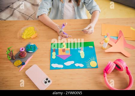 Jeune fille appréciant l'artisanat créatif à la maison avec du papier coloré et de l'argile sur une journée de week-end ensoleillée à l'intérieur Banque D'Images