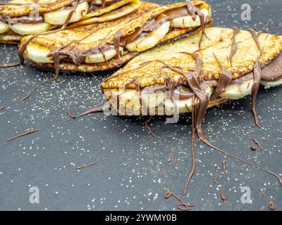 crêpes aux tranches de banane et chocolat servies sur ardoise Banque D'Images