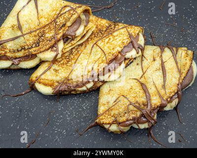 crêpes aux tranches de banane et chocolat servies sur ardoise Banque D'Images