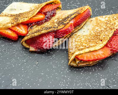 crêpes aux fraises et crème et chocolat servis sur ardoise Banque D'Images