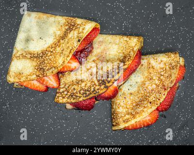 crêpes aux fraises et crème et chocolat servis sur ardoise Banque D'Images