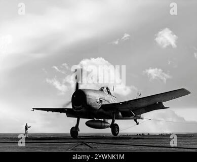 Le Grumman F6F Hellcat atterrissant sur un pont d'envol de porte-avions était un chasseur américain de la seconde Guerre mondiale, conçu pour remplacer le F4F Wildcat et contrer le Mitsubishi A6M Zero japonais. L'avion a fait ses débuts au combat en septembre 1943 et s'est par la suite imposé comme un chasseur robuste et bien conçu et est devenu le chasseur dominant de l'United States Navy dans la seconde moitié de la guerre du Pacifique. Au total, 12 275 avions ont été construits en un peu plus de deux ans et les Hellcats ont été crédités de la destruction d'un total de 5 223 avions ennemis en service. Banque D'Images