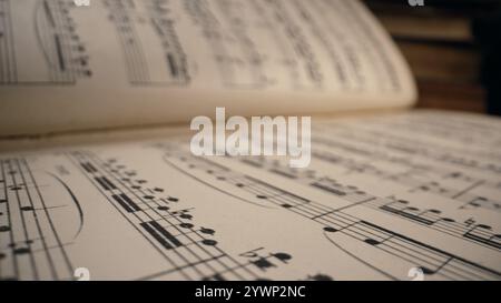 Macro arrière-plan de livre médiéval sauvegardé avec des écrits de notes musicales antiques. Texture de vieille symphonie classique manuscrite, belle mélodie, passe-temps Banque D'Images