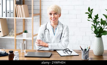 Visite d'un thérapeute au bureau. Femme souriante médecin assis à table Banque D'Images