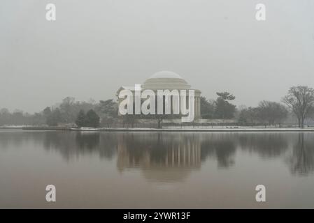 Vue hivernale du Jefferson Memorial reflétée dans les eaux calmes du Tidal Basin par une journée brumeuse à Washington, D.C. Banque D'Images