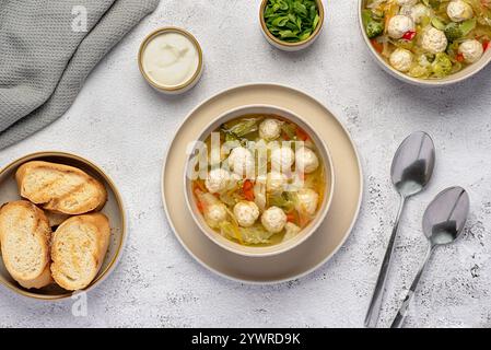 Photographie alimentaire de soupe avec boulettes de poulet et légumes, carottes, chou, brocoli, pommes de terre, poivron, bouillon, pain grillé, oignon de printemps, Banque D'Images