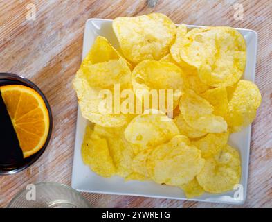 Assiette de croustilles croustillantes servies avec un verre de vermouth rouge Banque D'Images