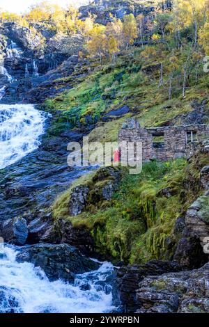 Huldra le séducteur dans la robe rouge fluide danse et chante à côté de la cascade de Kjosfossen dans la vallée de Flamsdalen. Huldra est une figure du folklore de la mythologie nordique Banque D'Images