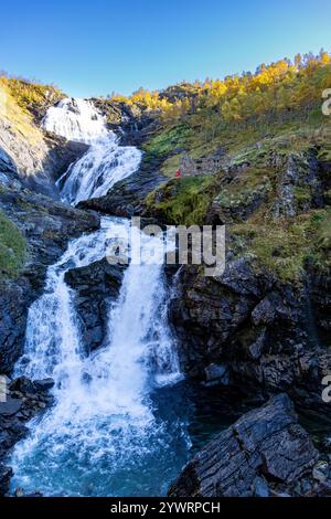 Huldra le séducteur dans la robe rouge fluide danse et chante à côté de la cascade de Kjosfossen dans la vallée de Flamsdalen. Huldra est une figure du folklore de la mythologie nordique Banque D'Images