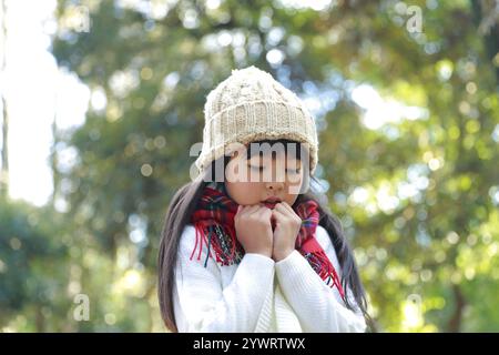 Fille avec un geste froid portant un bonnet tricoté Banque D'Images