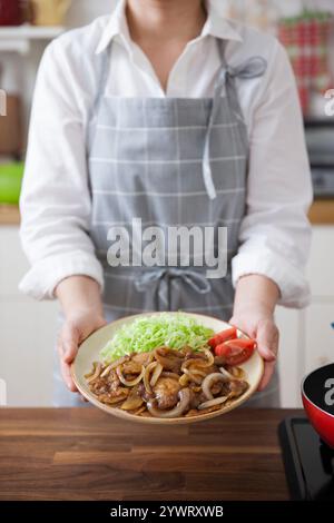 Femme tenant une assiette de pain d'épices de porc Banque D'Images