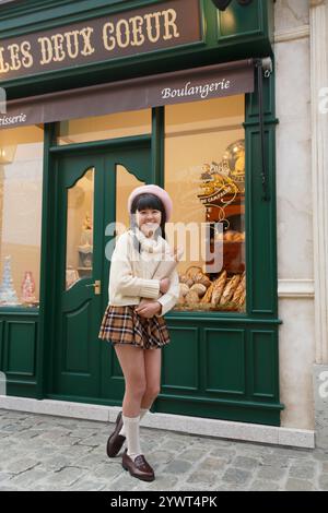 Fille debout devant la boulangerie Banque D'Images