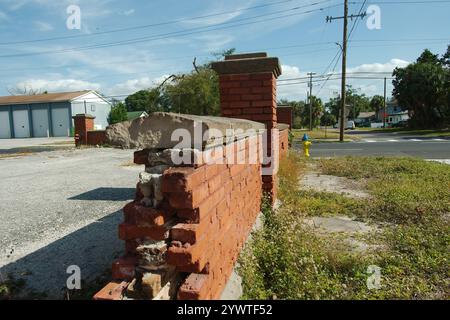 Ligne d'attaque vers le bas bord cassé Vieux mur de maçonnerie rouge avec ciel bleu vif. Motif rectangle de briques avec rue à l'arrière. Banque D'Images