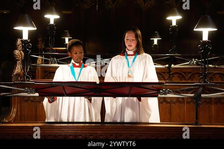 Les choristes en chef de la cathédrale de Gloucester Joel (à gauche) et Ella chantent dans la Quire avant les répétitions pour les cathédrales à venir Advent Carol services. Date de la photo : mercredi 11 décembre 2024. Banque D'Images